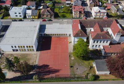 Zadní trakt školy se školním hřištěm.